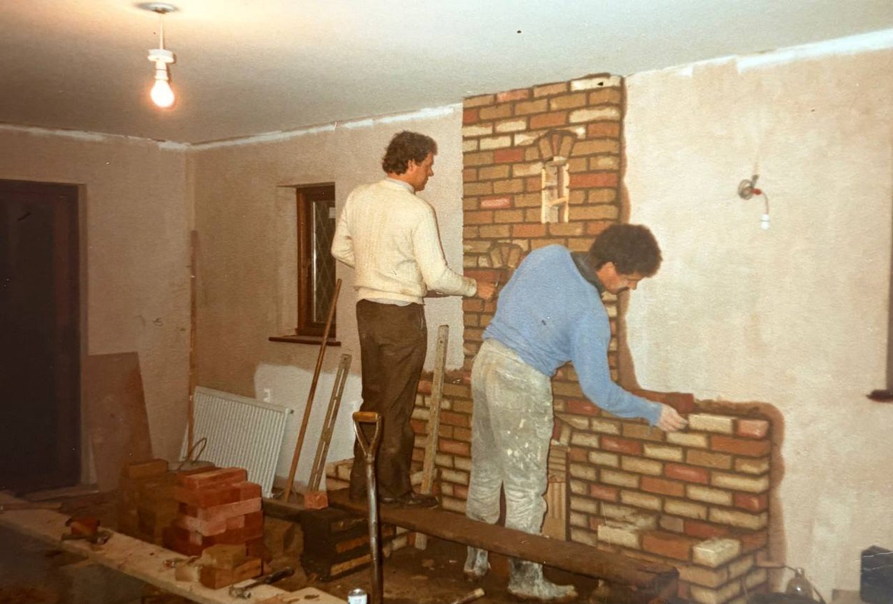 Paul and Terry Pocock building a brick fireplace